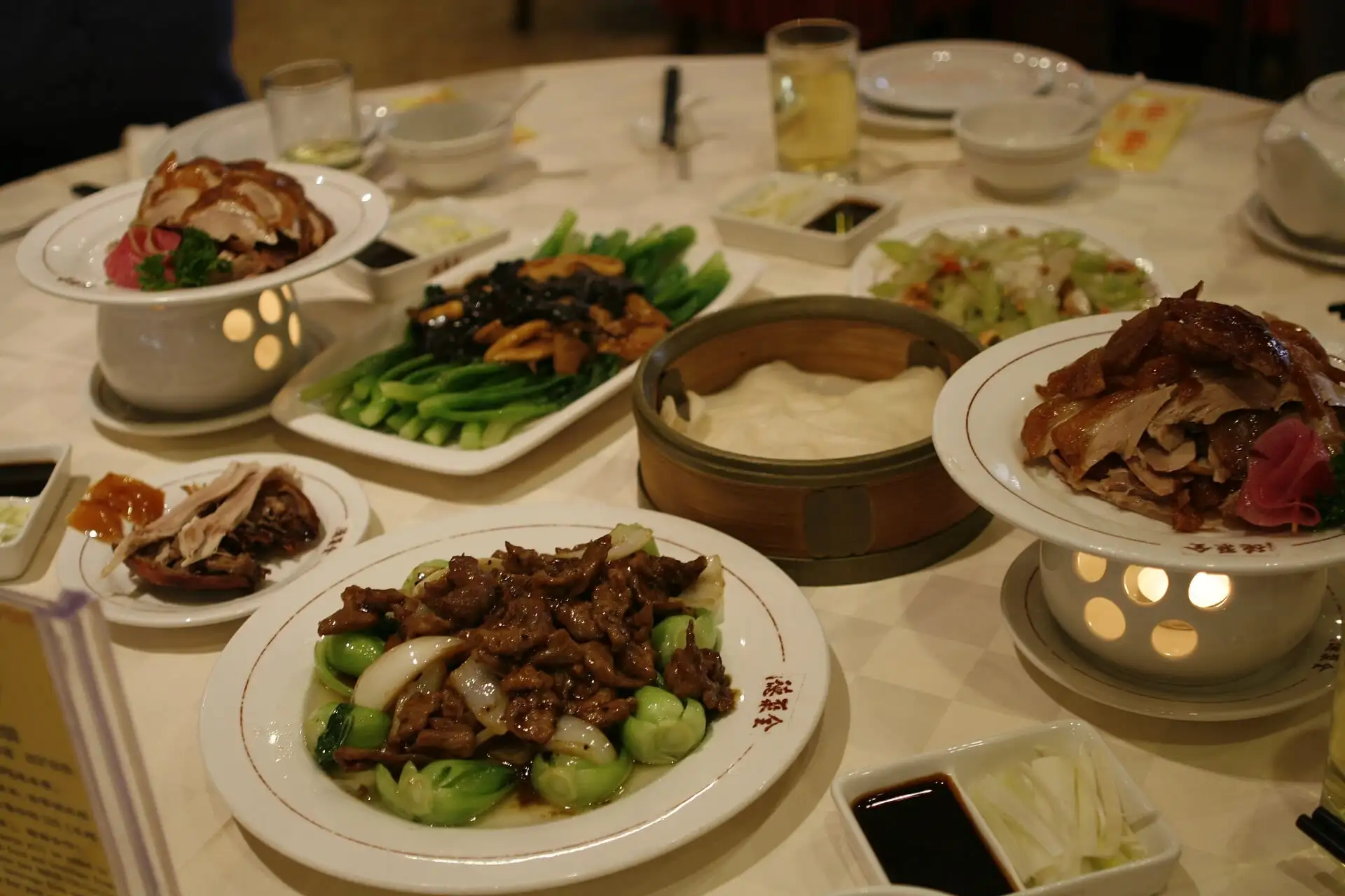 A table of dishes with sliced Peking duck at a Beijing restaurant