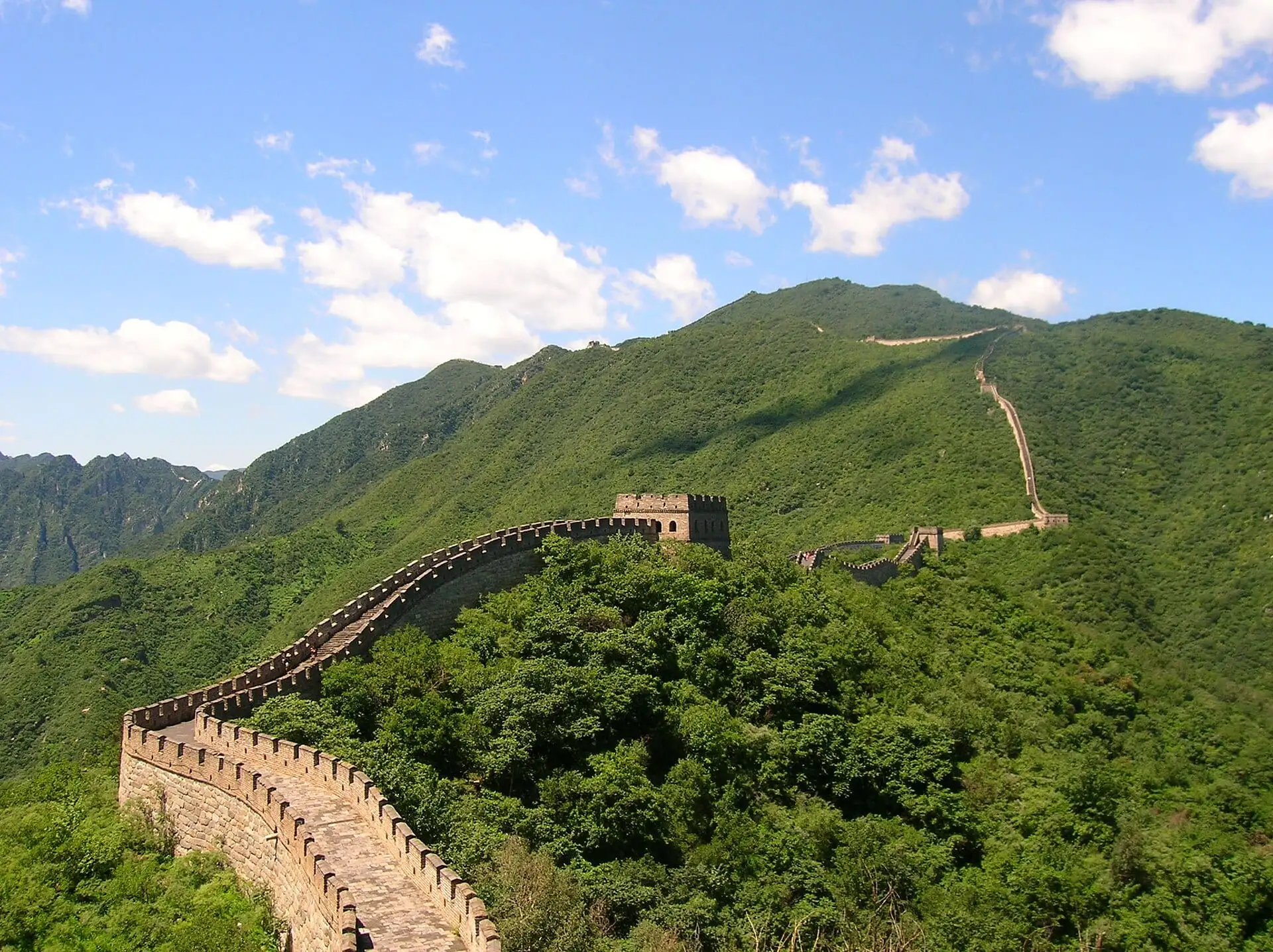 The Great Wall of China winding over green hills